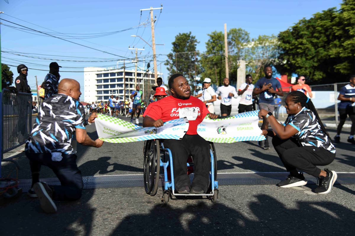 Finishing first in his division, Marcus Banton happily wheels across the finish line on Sunday at the annual Sigma Corporate Run.