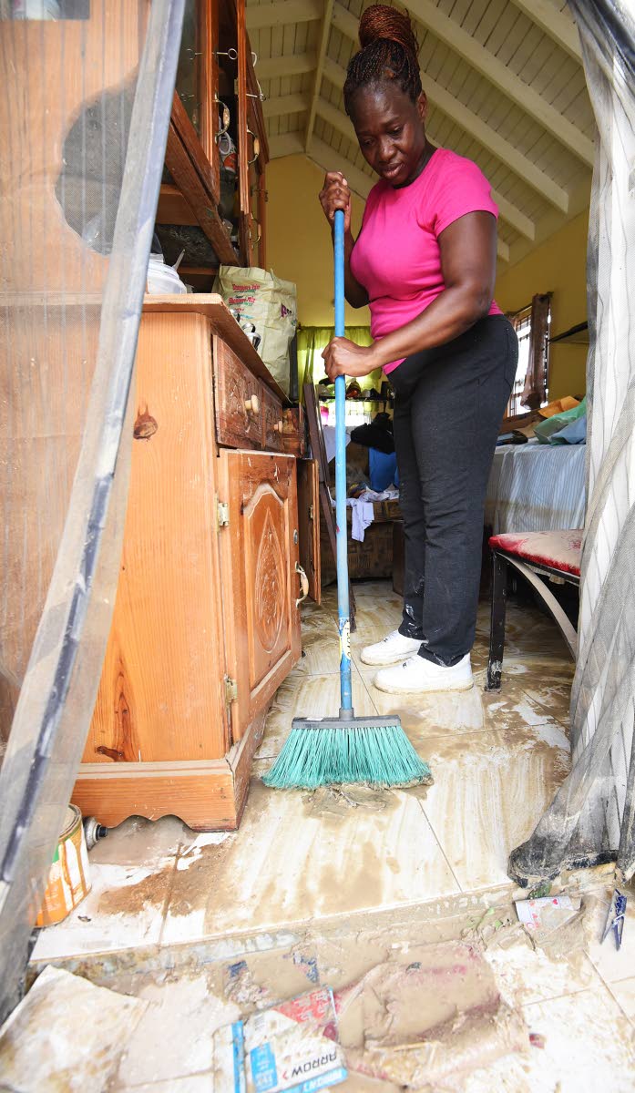 
Aneita Williams cleaning mud from her house in The Estuary, a housing development in Friendship, St James, after the passage of Hurricane Melissa last October. Now displaced and given temporary accommodation by the NHT, she does not wish to return to her 