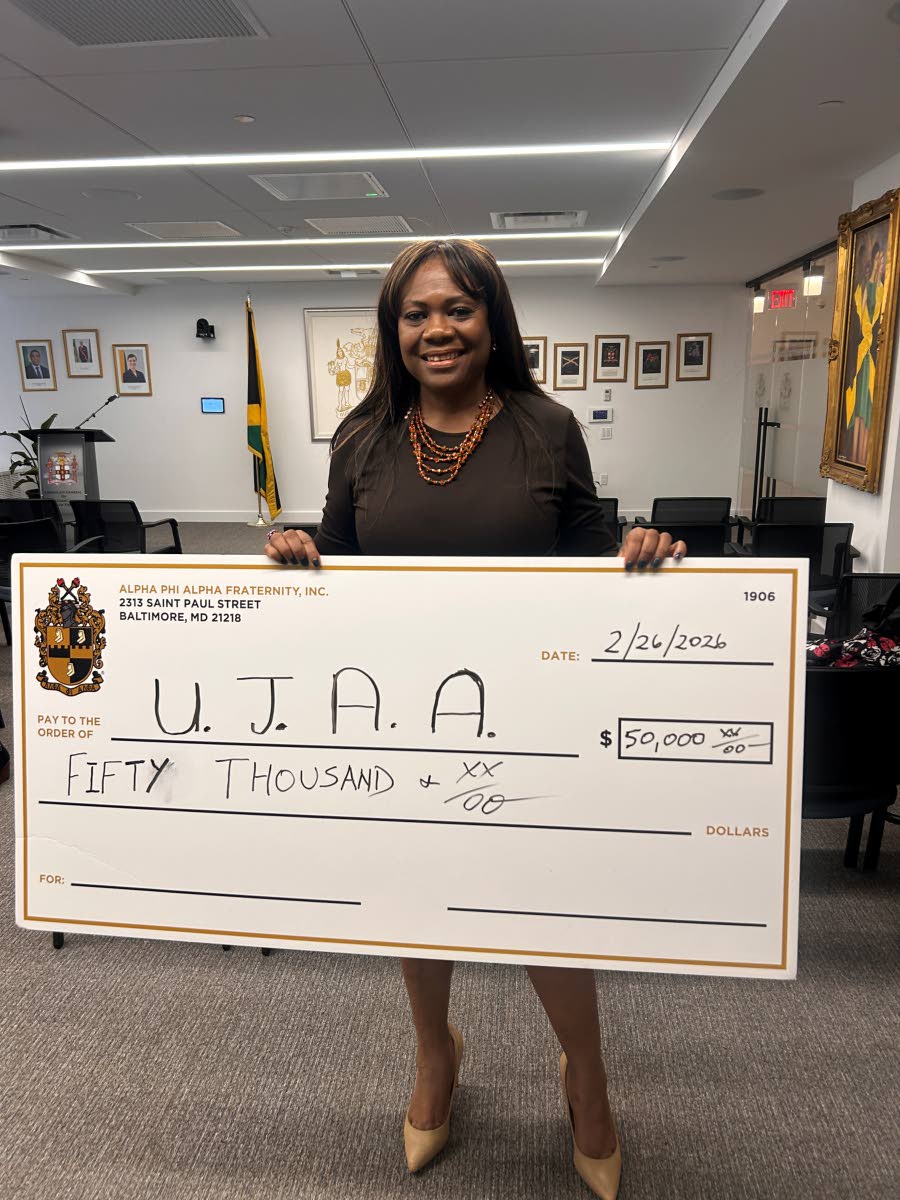 Debbie Mercer-Miller shows of the cheque to be donated the to three hurricane-affected schools. 