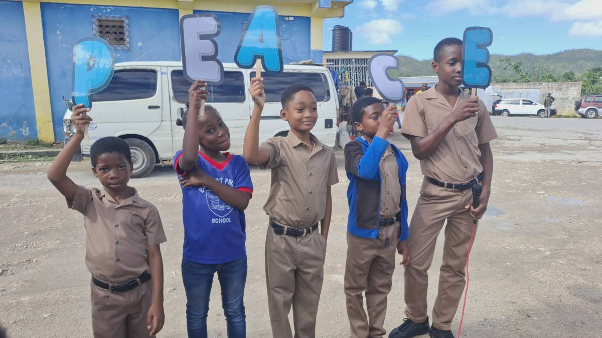 Students of Beaufort Primary School hold up letters spelling the word ‘PEACE’ while performing an item during the school’s Peace Day devotion in Darliston, Westmoreland, yesterday. 