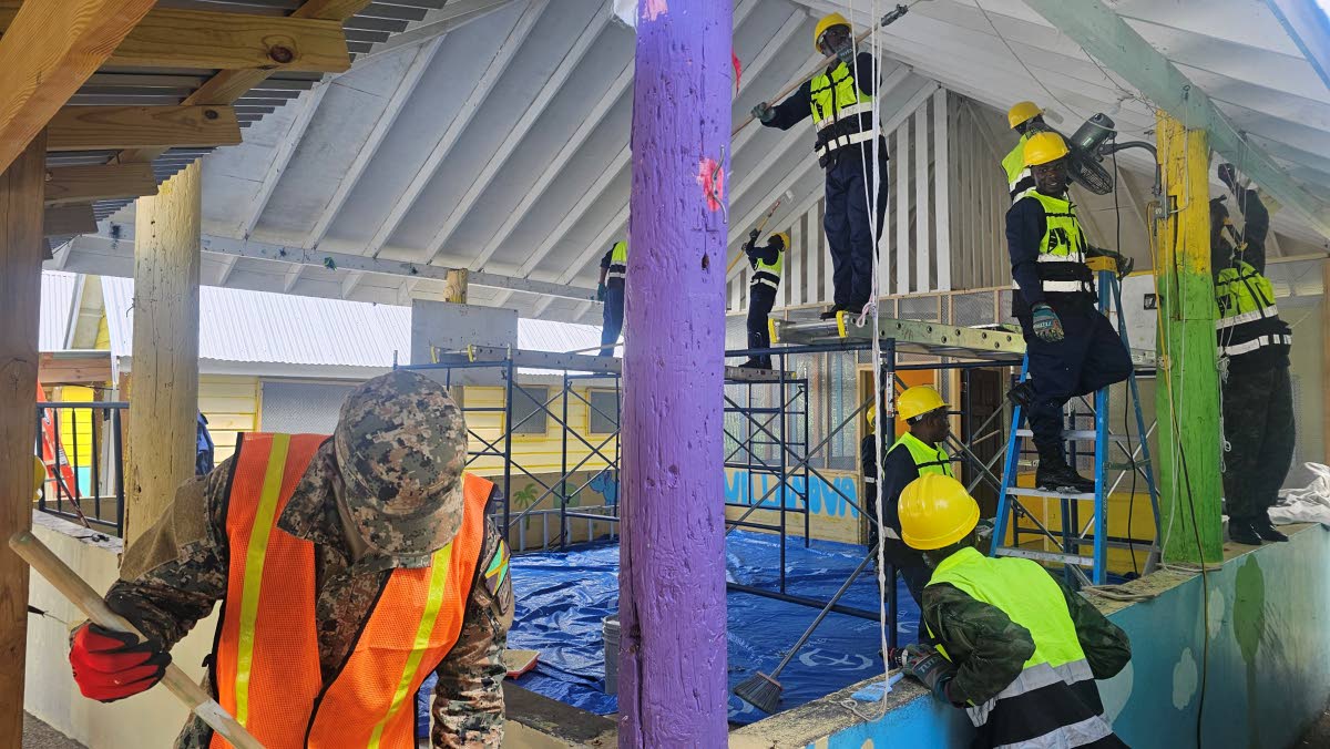 Members of the Jamaica Defence Force work alongside engineers from the Rwanda Defence Force in carrying out painting and restoration work at Blessed Assurance Children’s Home on Saturday February 28 in Adelphi St James.