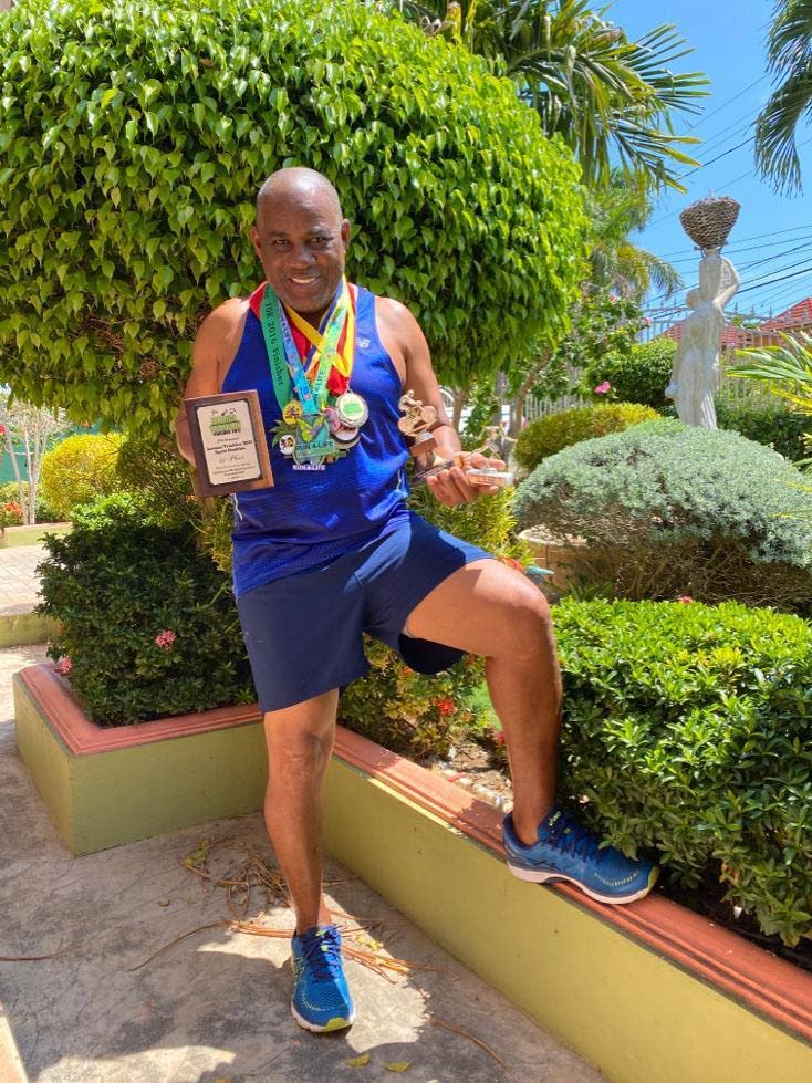 Howard Ward displays medals and plaques earned from various races and philanthropic awards and recognition. 