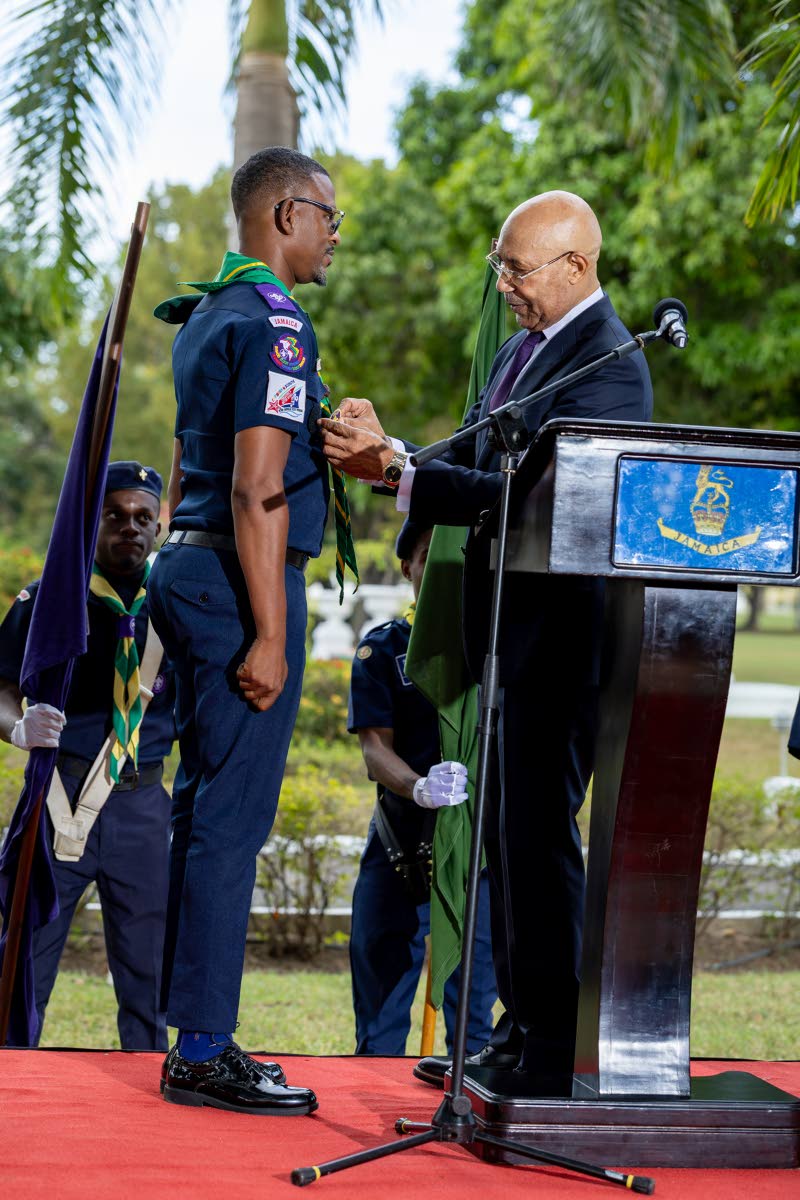 Sir Patrick Allen, governor general and chief scout of Jamaica, affixes the chief commissioner’s badge of office on Kevin Richards during his installation at King’s House in St Andrew on February 26.