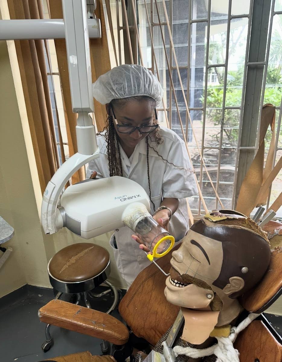 Focused on precision, Cohall-Cunningham takes dental X-Rays on a mannequin as part of her hands-on training.