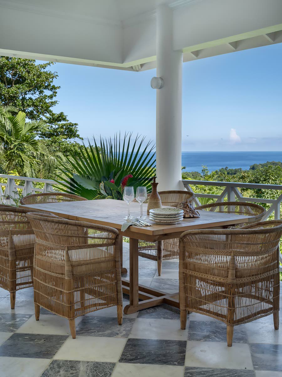 
The outdoor dining terrace seems to float above trees and the sea in the distance.
