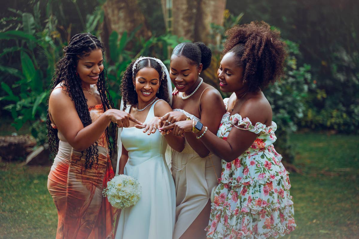 The bridal party in awe of Kady-Ann’s (second left) wedding ring. From left: Nastassia Rowe, Audra Wilson and Shelly-Ann Higgins.