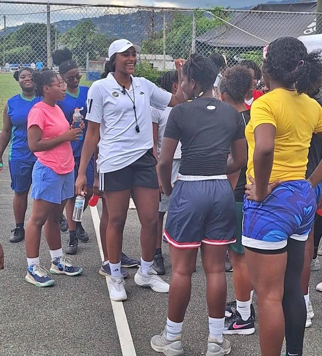 Aaliyah Edwards (white cap) speaks with basketball players during her ‘You Got Knext’ girls basketball camp at the Queens School.