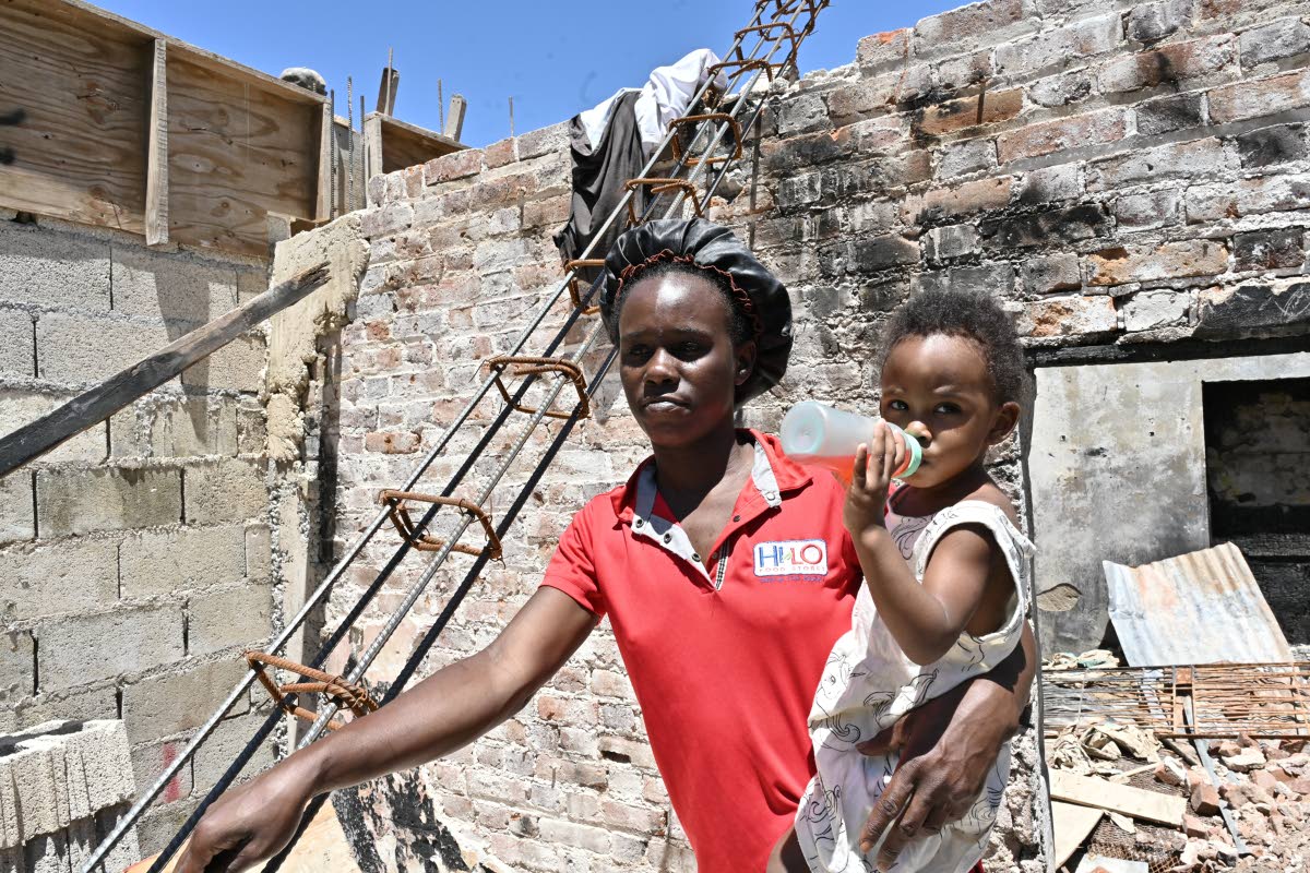 Fire victim Kimonia Thomas and her baby, D’milliana Lucas, are among 13 relatives left homeless after fire destroyed their home at 10 Old Market Street in Spanish Town, St Catherine, a month ago.
