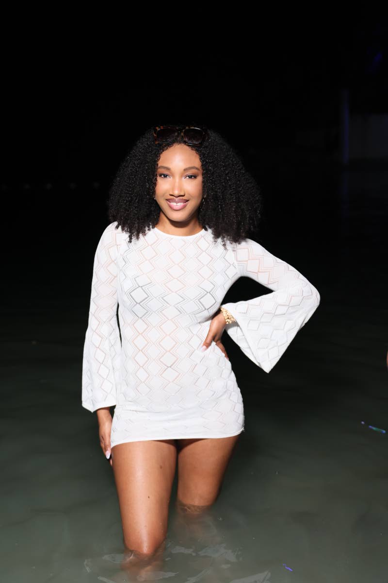 Fredricka Campbell poses on the shoreline at Porti Beach in a mesh chequered shift dress. 