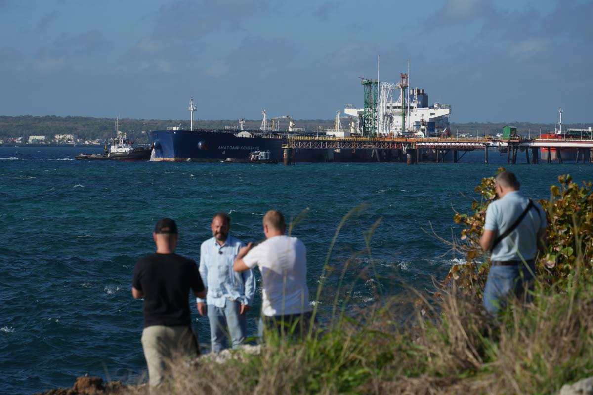 Journalists do a standup in front of the Russian-flagged oil tanker Anatoly Kolodkin docked in Matanzas, Cuba.