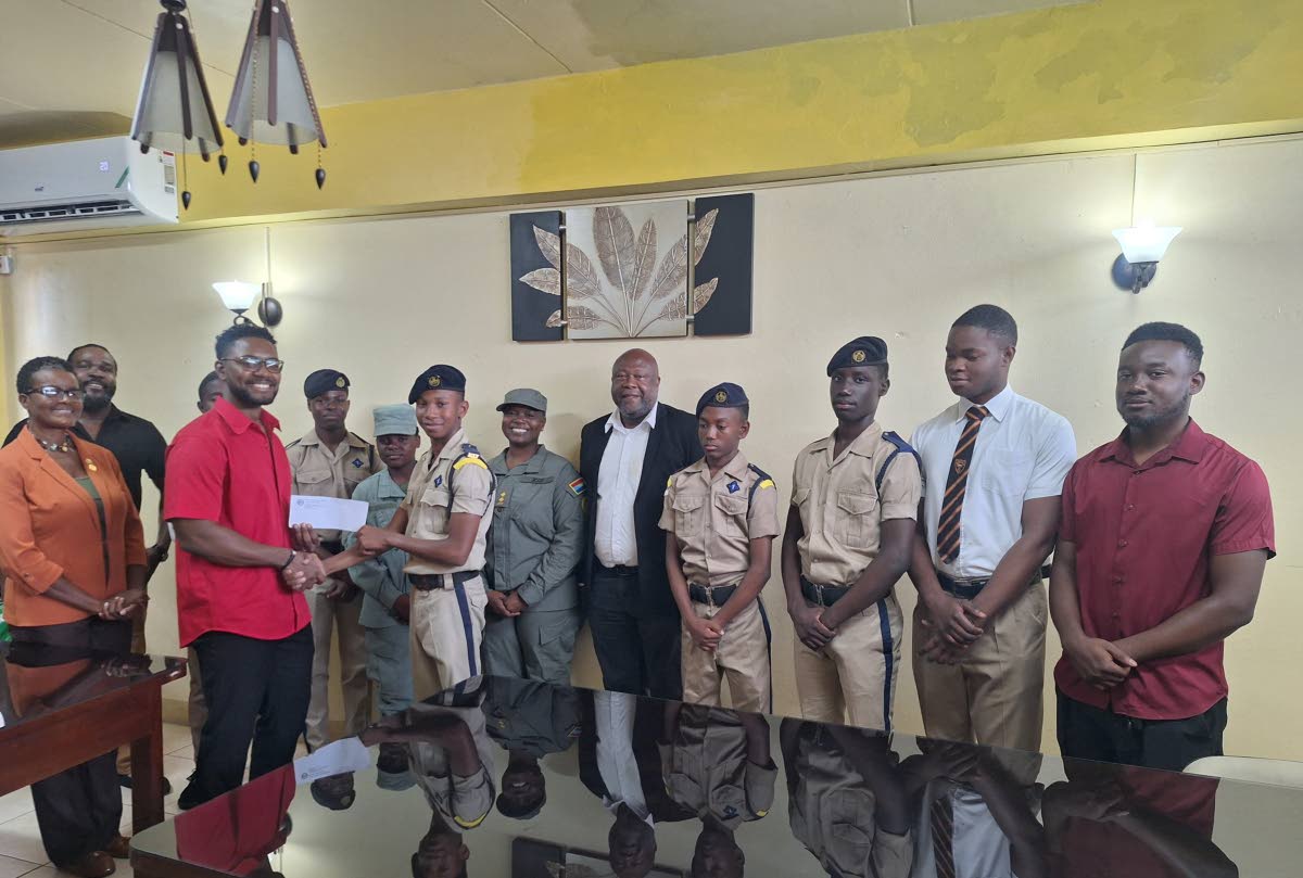 Odaine Thomas, junior warden of Friendly Lodge 383, presents a cheque on behalf of the Freemason Association of Jamaica to Lance Corporal Andrew Cammock of the Cornwall College Cadet Unit. Sharing in the occasion are Lecia Allen (left), vice-principal of C
