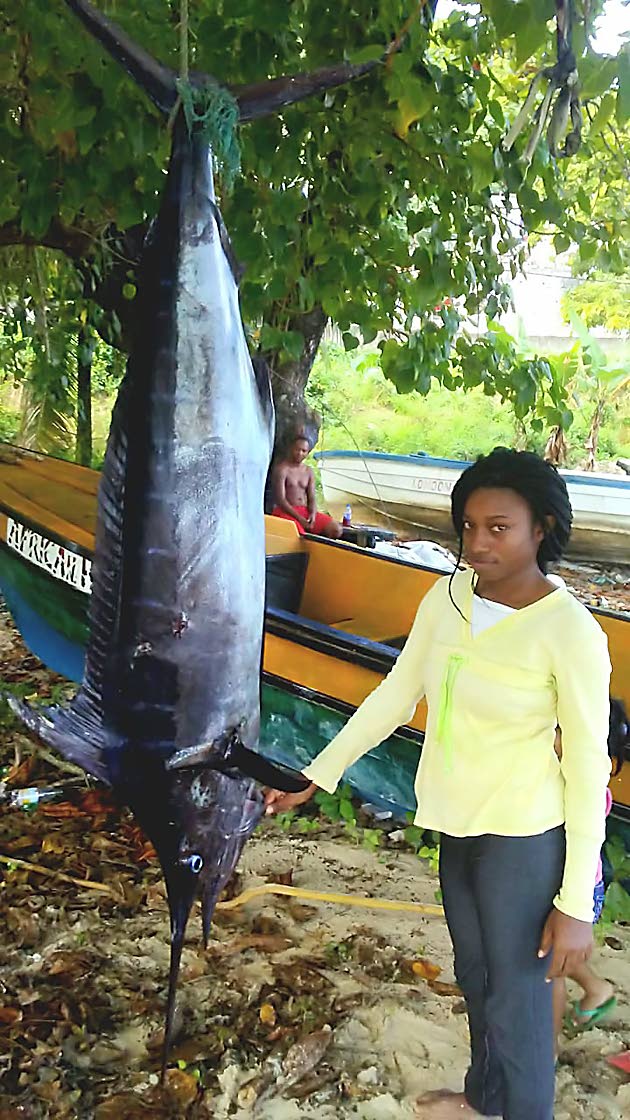 Female fisher Sashae Shaw stands next to a fish at the Old Marina, in Portland, recently. 