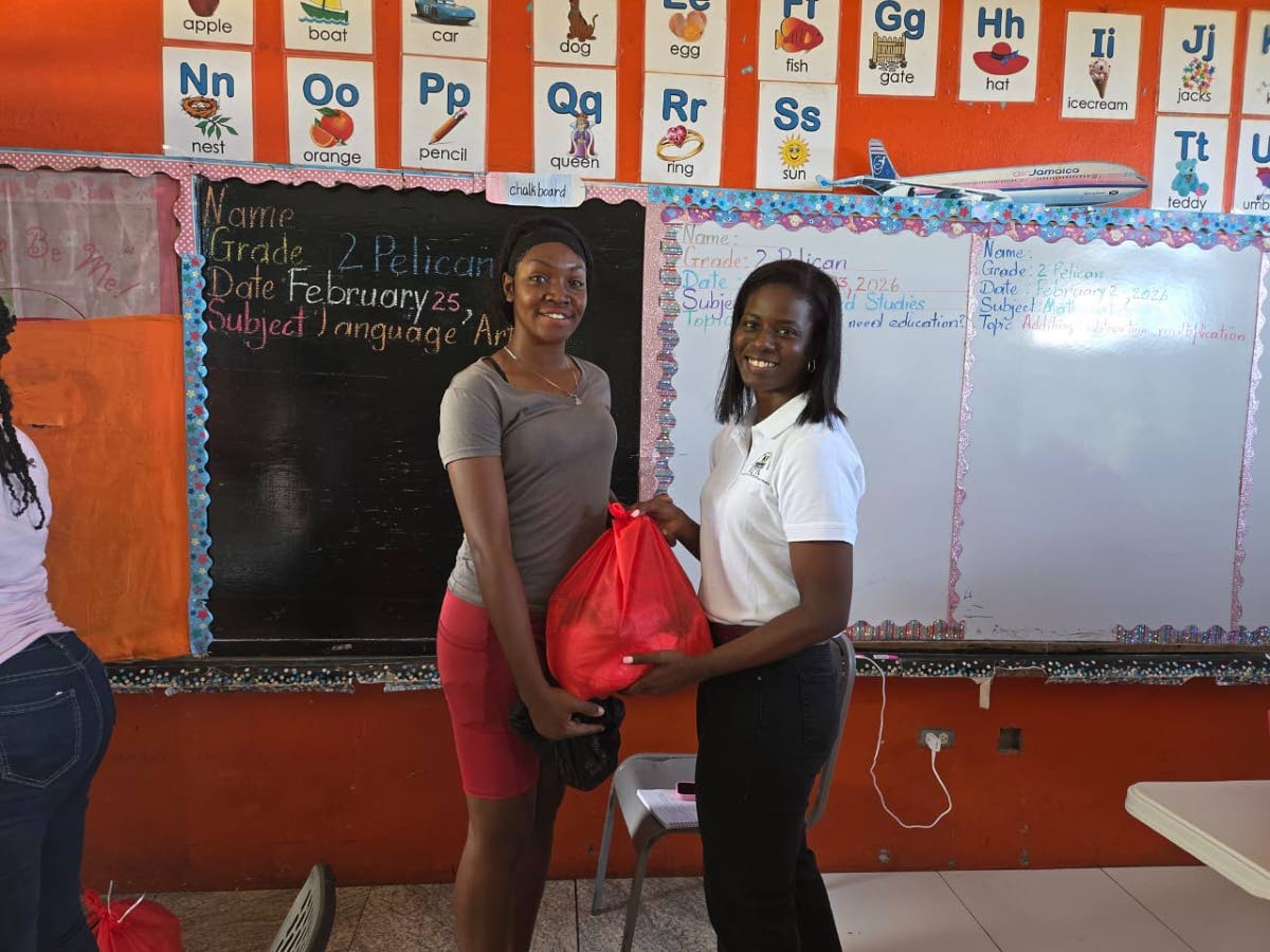 Jonelle Llewellyn, research associate at the Violence Prevention Alliance presents a care package to a resident of Chalky Hill in St. Ann.