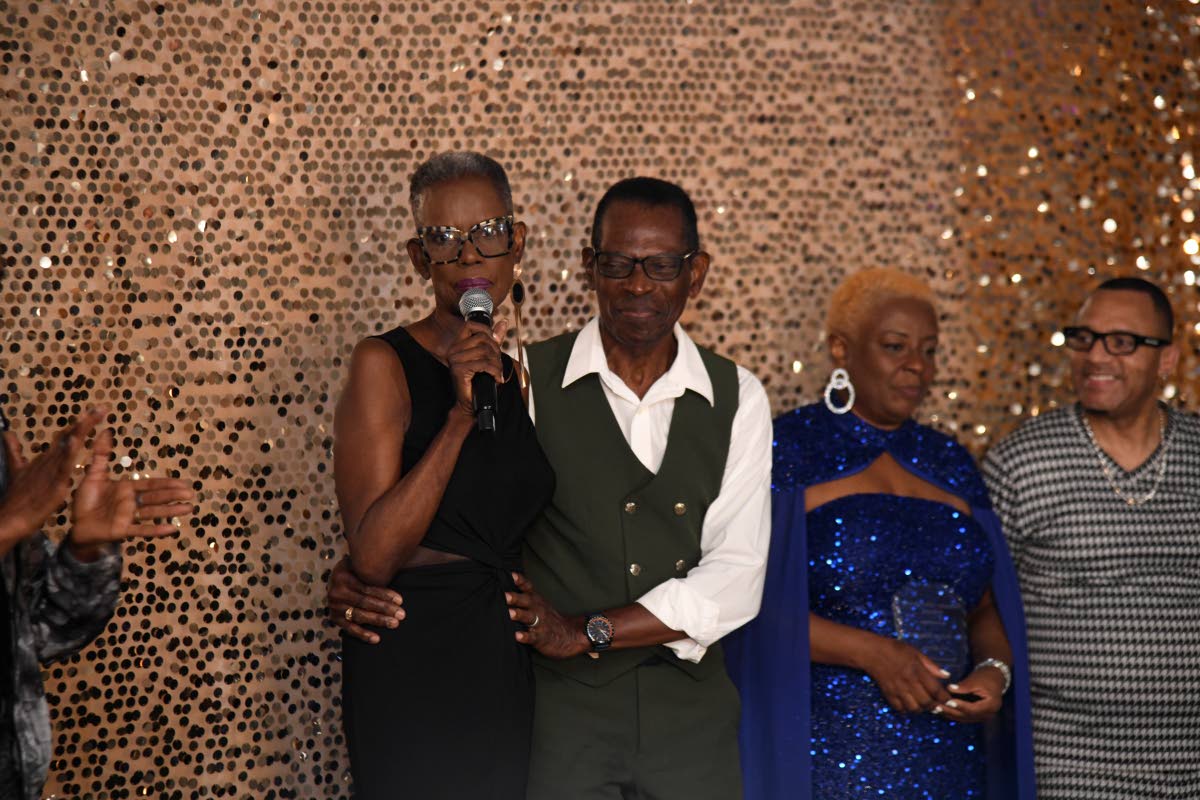Honoured as a trailblazer at the Fashion Elevation event, Althea Laing (left) offers her thanks as one of the organisers, Weston Haughton (second left), embraces her.