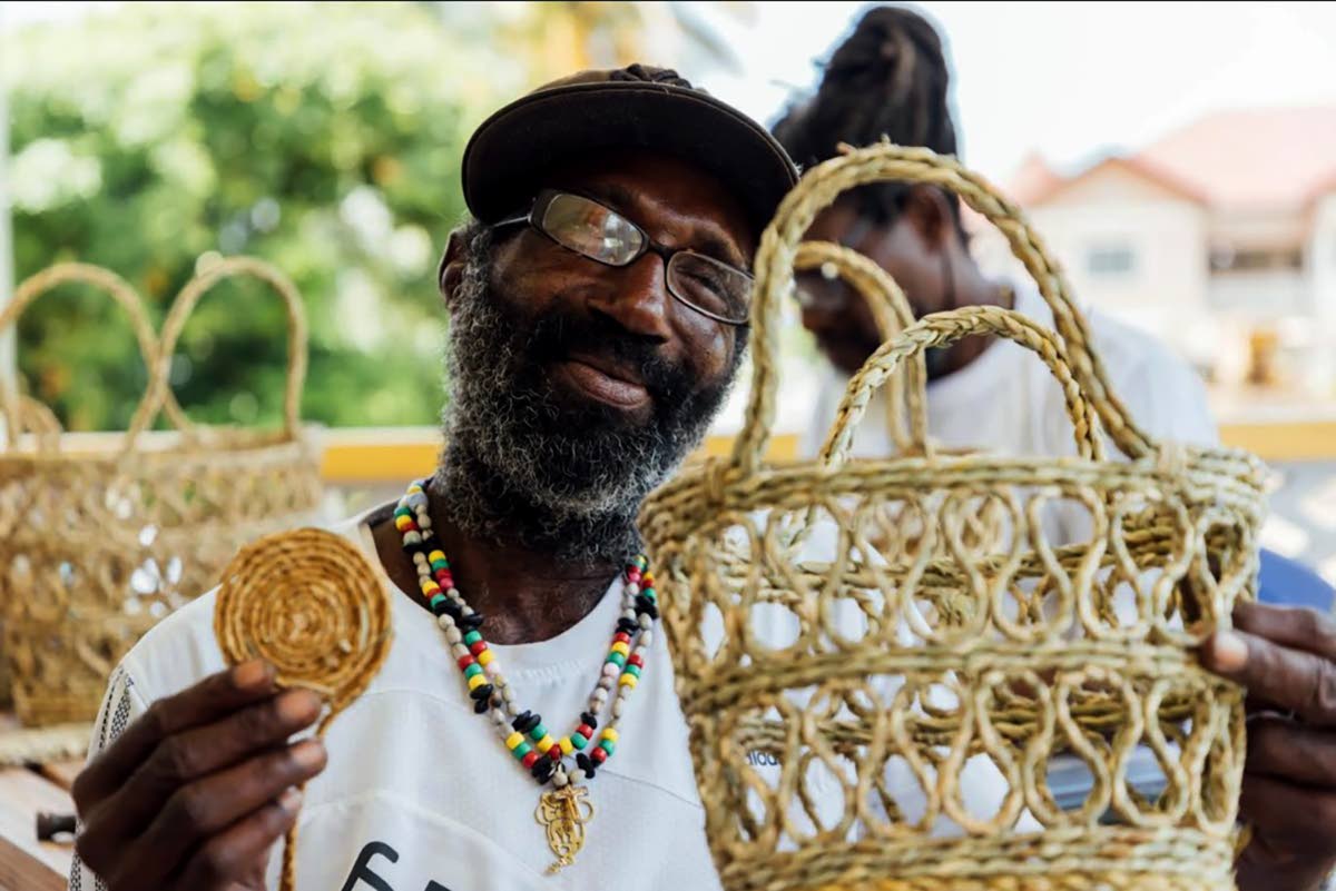 A craft vendor in St. Vincent and Grenadines poses with products made from vetiver grass. 