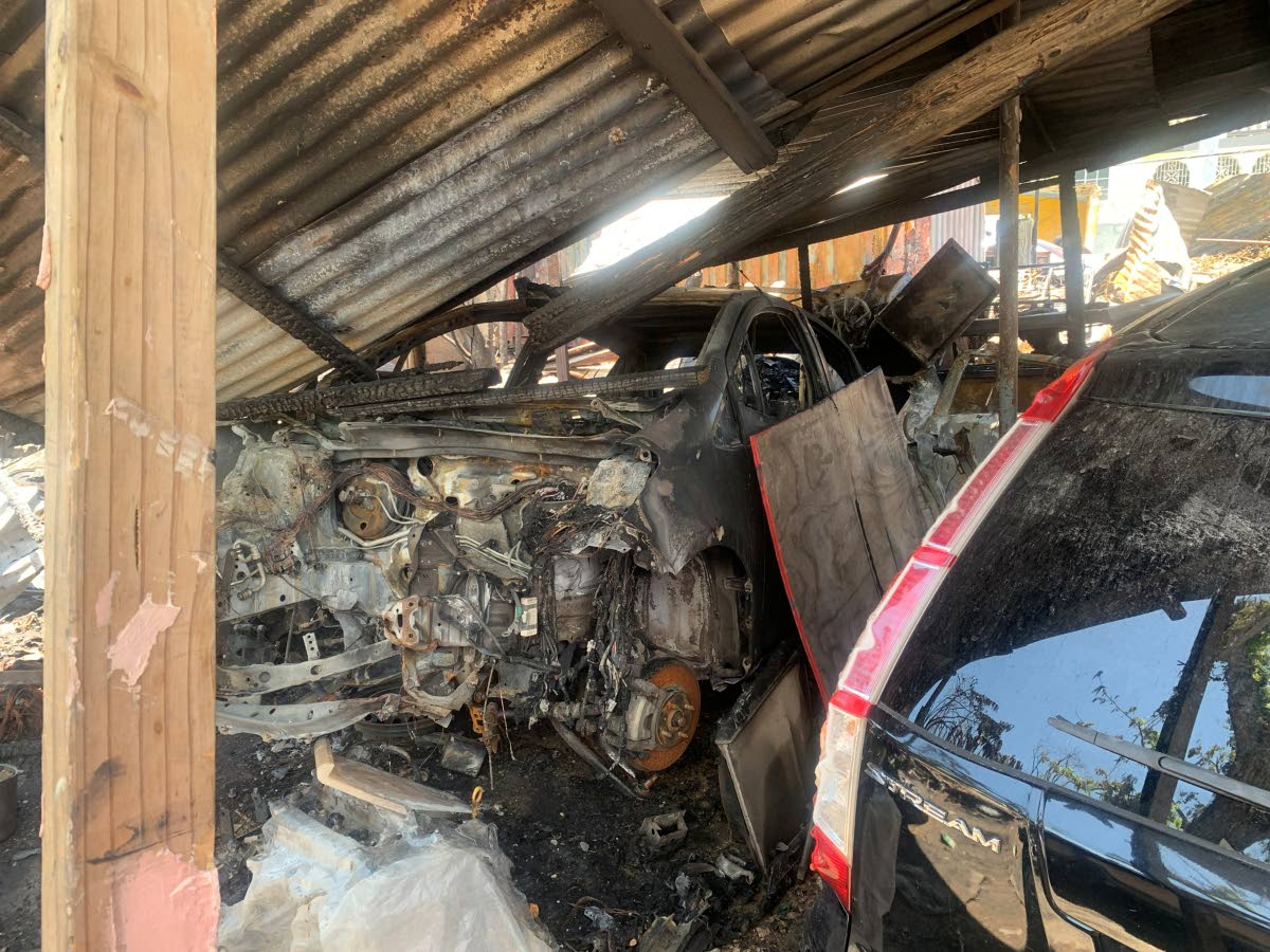 The shell of a burnt-out car at a bodywork shop following a fire on Tuesday.