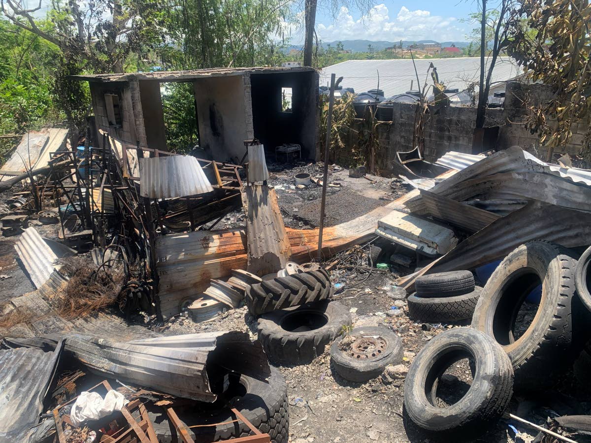 The remains of Canute James’ four‑apartment house are seen in the background.
