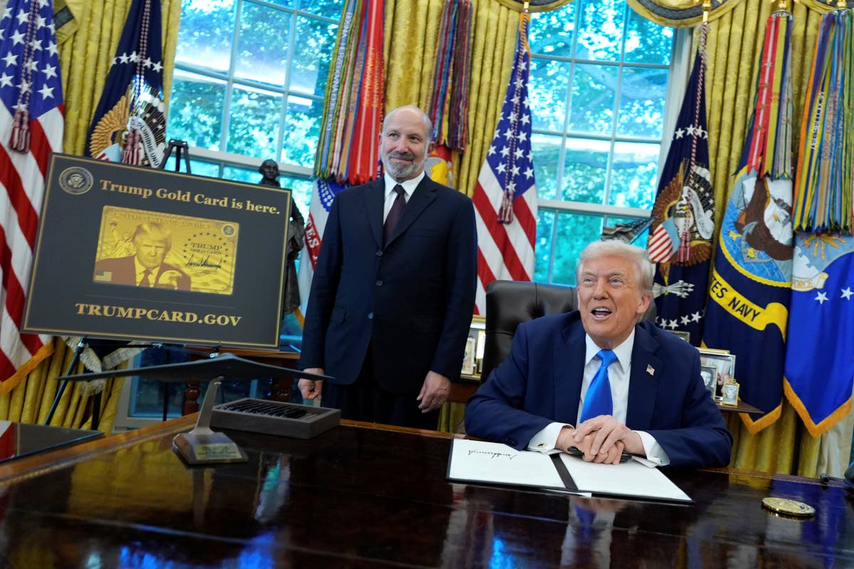 President Donald Trump speaks as Commerce Secretary Howard Lutnick listens alongside a poster of the Trump Gold Card in the Oval Office of the White House, Friday, September 19, 2025, in Washington. (AP Photo/Alex Brandon)
