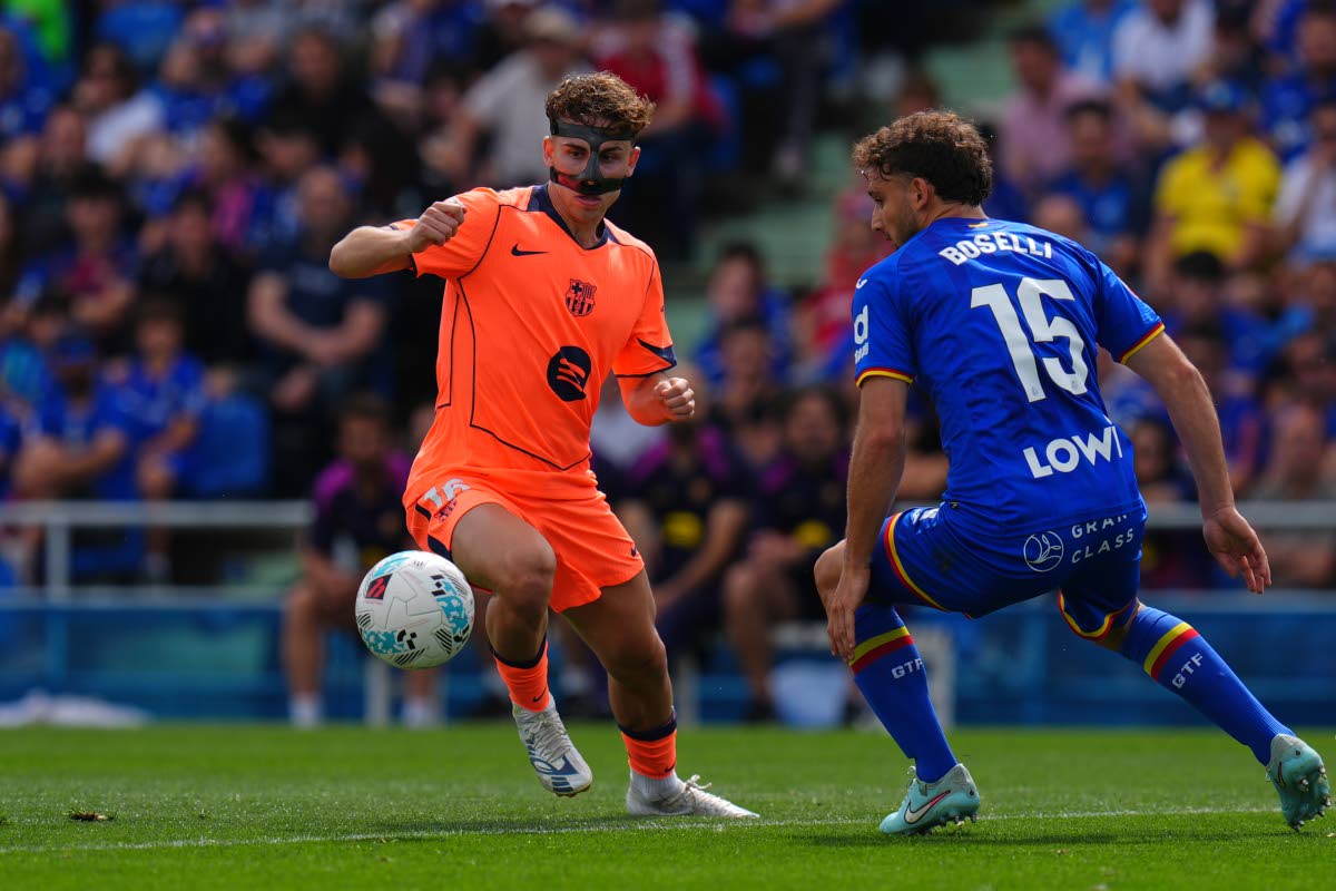 Barcelona's Fermin Lopez, left, and Getafe's Sebastian Boselli compete for the ball during the Spanish La Liga football match between Getafe and Barcelona in Getafe, Spain on April 25, 2026. (AP hoto/Manu Fernandez)