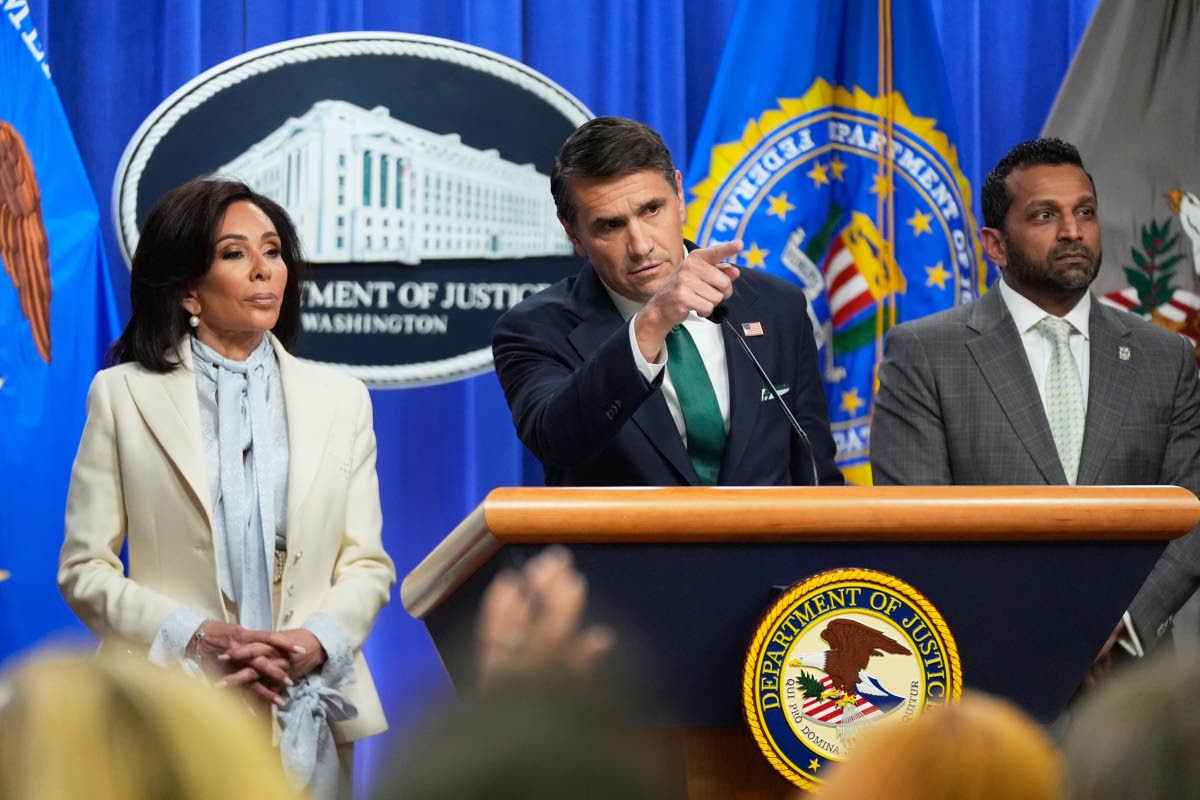 Acting Attorney General Todd Blanche, with U.S. Attorney Jeanine Pirro, left, and FBI Director Kash Patel, right, speaks during a news conference at the Department of Justice, on Monday April 27, 2026, in Washington, following the initial appearance in fed