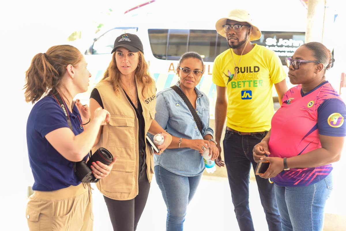 Members of the Corus International team, Amy Vu (left) and Emily Grose (second left), engage in conversation with Claudine Allen (centre), general manager of the JN Foundation; Omar Wright (second right), lead for environment and community development pro