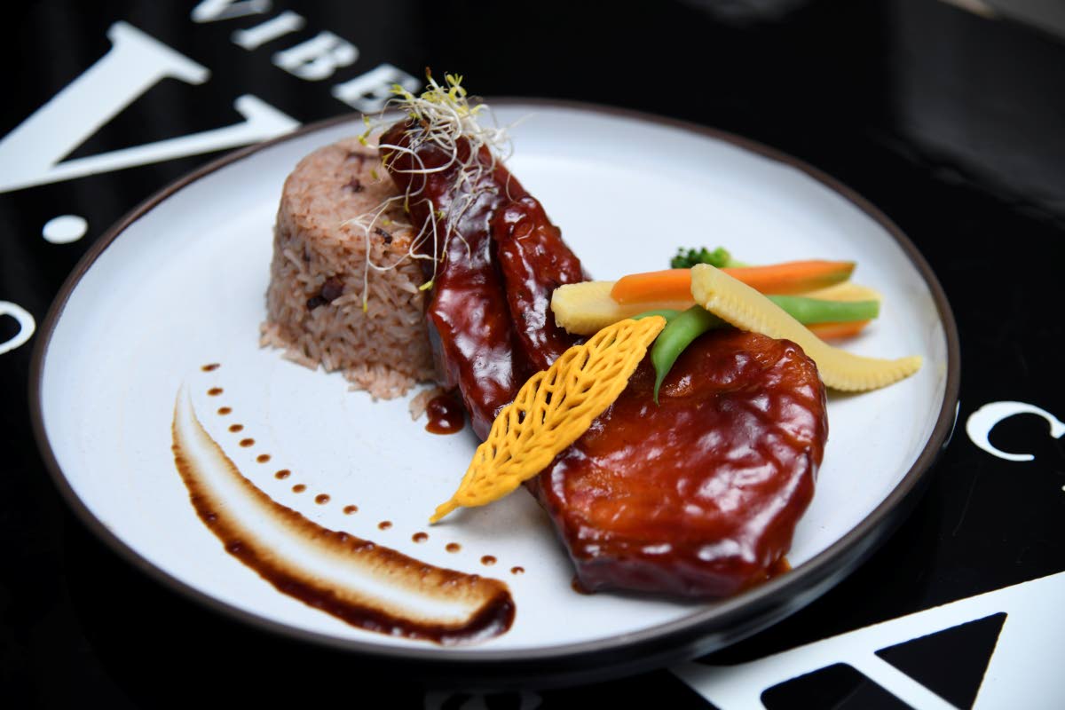 The smoked pork chops are served with traditional rice and peas and steamed vegetables.