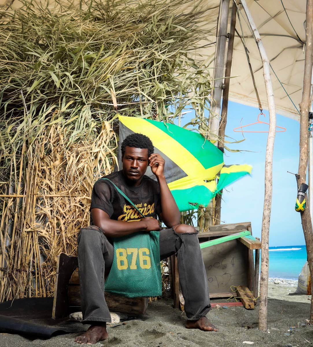 From left:Mr World Caribbean 2024 Tarique Barrett wears the 876 Black and Gold Mesh Jersey and poses with the 876 Green Mesh Tote Bag.