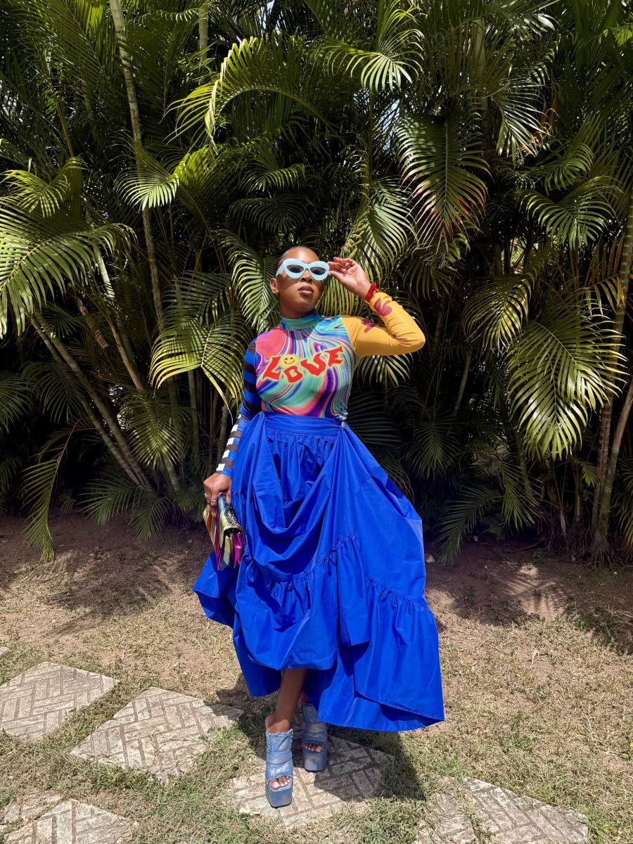 McLeggon embraces bold colour in a vibrant Salon Bouje top and voluminous royal-blue skirt from Lee’s Fifth Avenue, finished with shoes and a coordinating bag from Heel-O. 