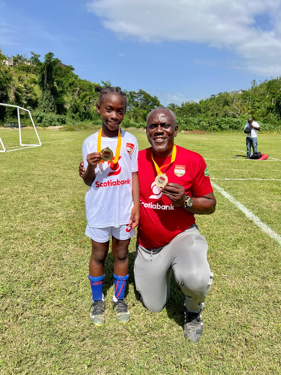 Rousseau Primary School’s Ricshi Scarlett and Head Coach Devon Smith celebrate after the school claimed the Scotia Kids Football Championships title.