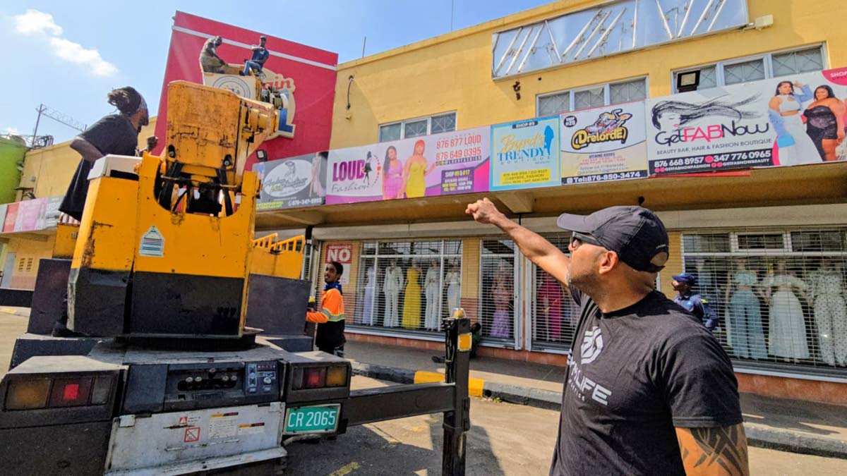 Chief Executive Officer of the KSAMC, Robert Hill (right) oversees an operation to remove unauthorised billboards.