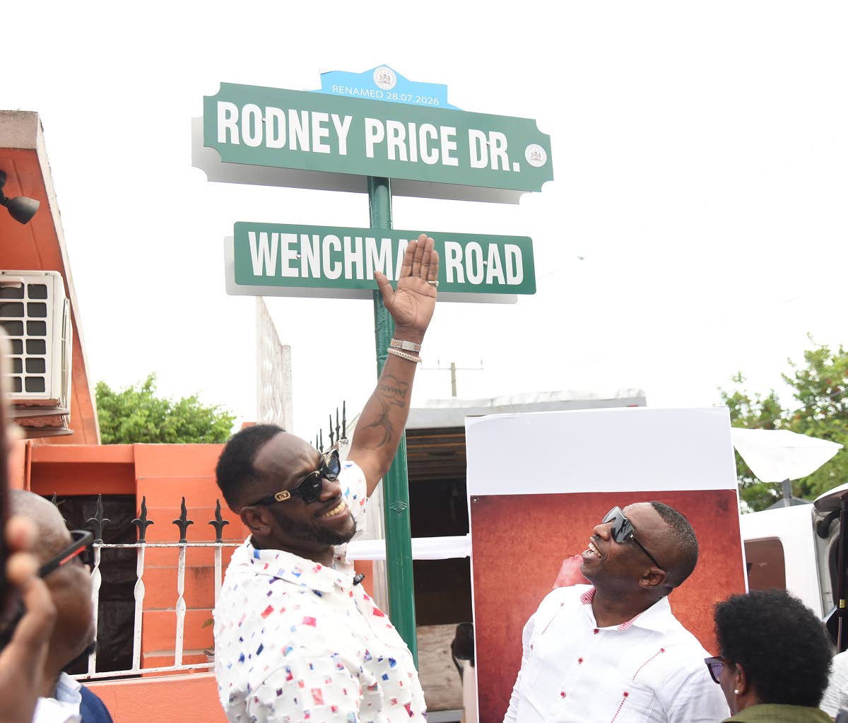 Rodney Price points to the newly unveiled Rodney Price Drive sign following the official renaming ceremony on Tuesday, while Mayor of Kingston Andrew Swaby looks on. 