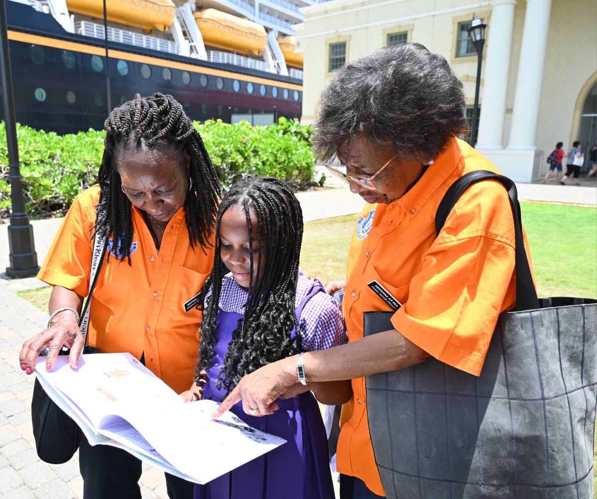 From left: Patricia Yarbrough, president Blue World Travel Corporation Featuring Festival at Sea is reading a book with 8-year old Victoria CHRISTIE, Pisgah Primary and Infant and Peggy Taylor Presley, Festival at Sea during the donation of books at the Fa