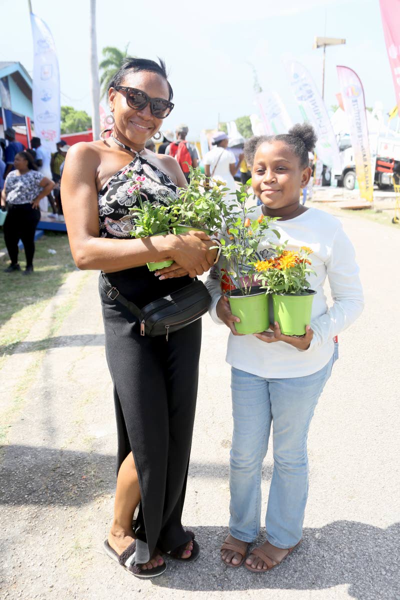 A woman and a young girl display flowers purchased at the Denbigh Agricultural, Industrial and Food Show in Clarendon.