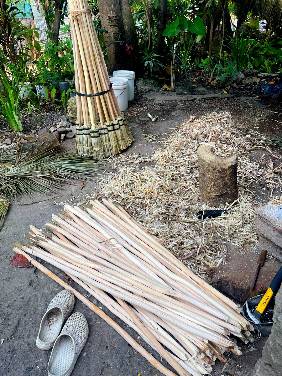 Prepared sticks, palm thatch and finished broom heads await assembly during the broom-making process.Prepared sticks, palm thatch and finished broom heads await assembly during the broom-making process.