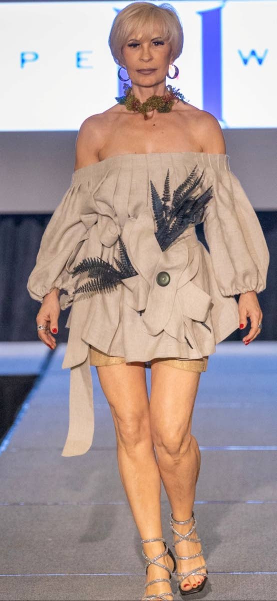 Gaby Haas wears a burlap pleated blouse with floral detailing and burlap shorts by Hope Wade.