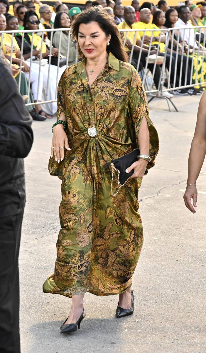 Rose Tavares-Finson, fitness professional and wife of Tom Tavares-Finson, president of the Senate, arrives in a green satin shirt-style maxi tunic with a crystal pin and black slingbacks. 