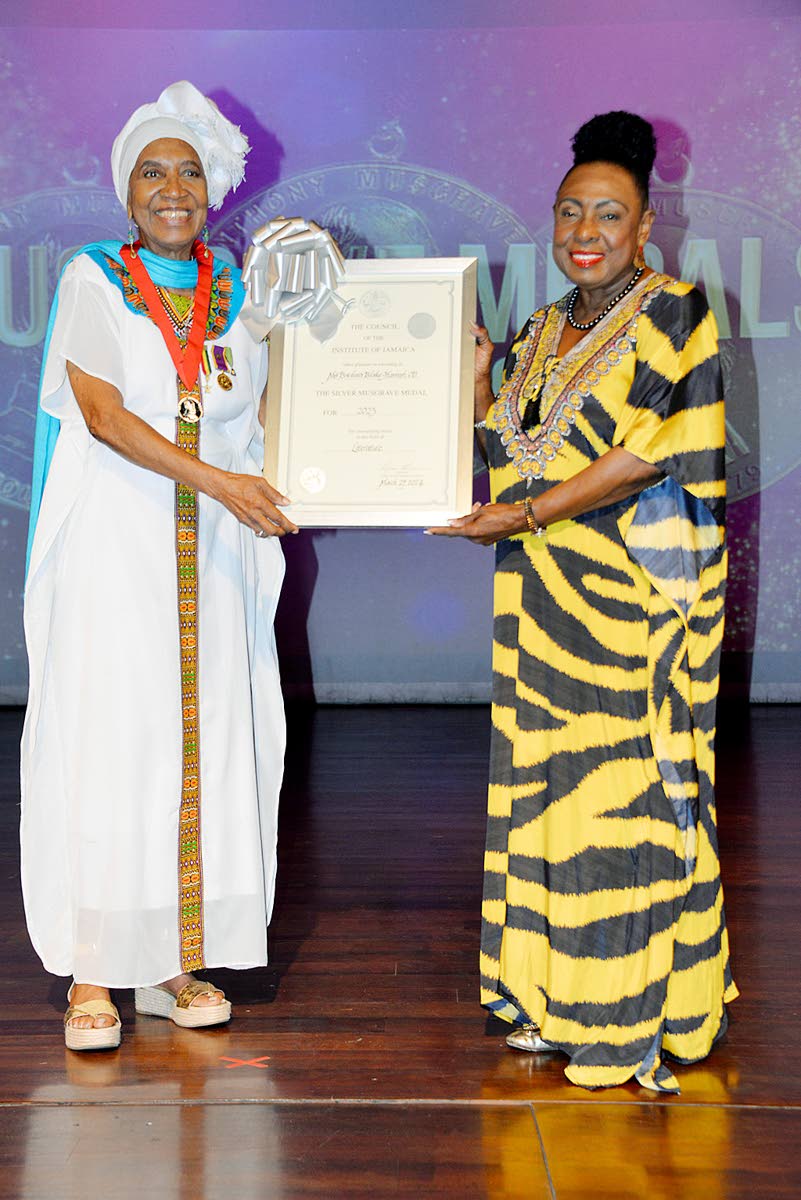 Barbara Blake-Hannah (left) receives her Silver Musgrave Medal and certificate for the Literature category from Minister of Culture, Gender, Entertainment, and Sport, Olivia Grange at the ceremony in March 2024.