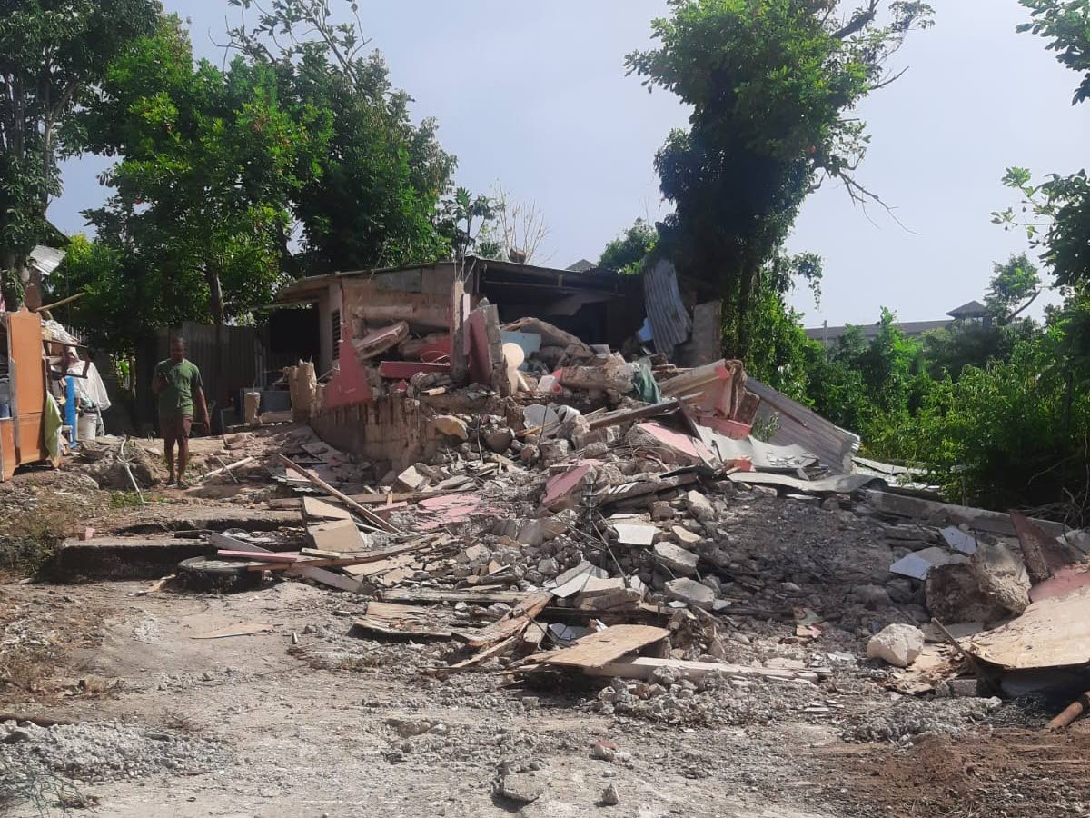 A resident walks among rubble near a demolished home in Cooper’s Pen, Trelawny.