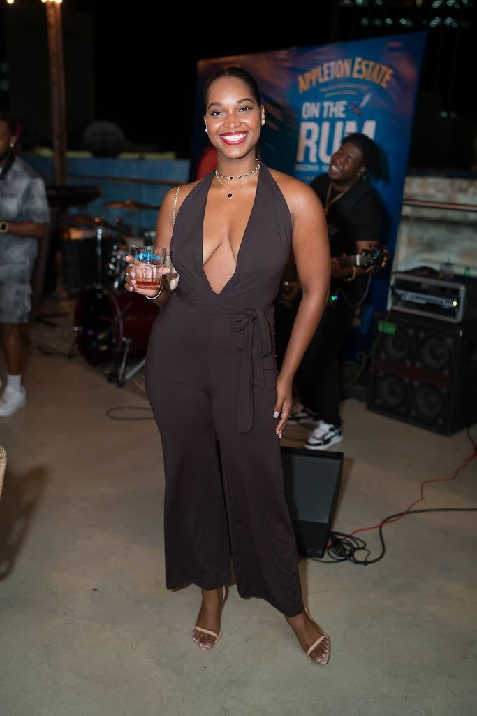 Mandy Cowan, sign language interpreter and TV host, dons a brown halter jumpsuit with a plunging neckline and strappy nude heels.
