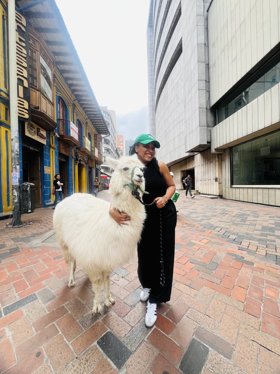 Smith hugs a white llama in the iconic La Candelaria neighbourhood of Bogota, Colombia.