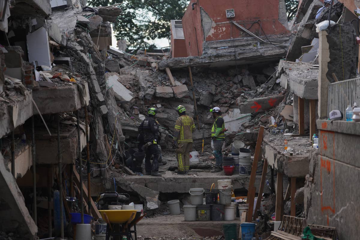 Firefighters search through the rubble last Thursday, three days after an earthquake struck Cali, Colombia,