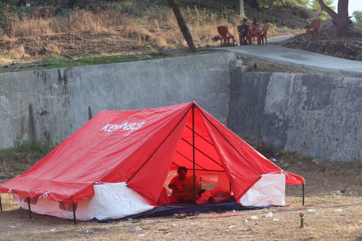 A woman sits inside a tent amid fear of aftershocks following an earthquake, in Reok, East Nusa Tenggara province, Indonesia, Sunday, Aug. 16, 2026. (AP Photo/Aquila Handayani Abbas)