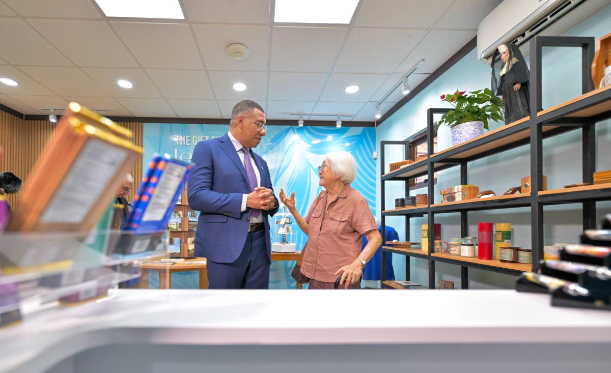 Prime Minister, Dr Andrew Holness (left), in conversation with Sister Grace Yap, Order of St. Francis (OSF), in the gift shop of the newly opened Alpha Mercy Historical Centre. 