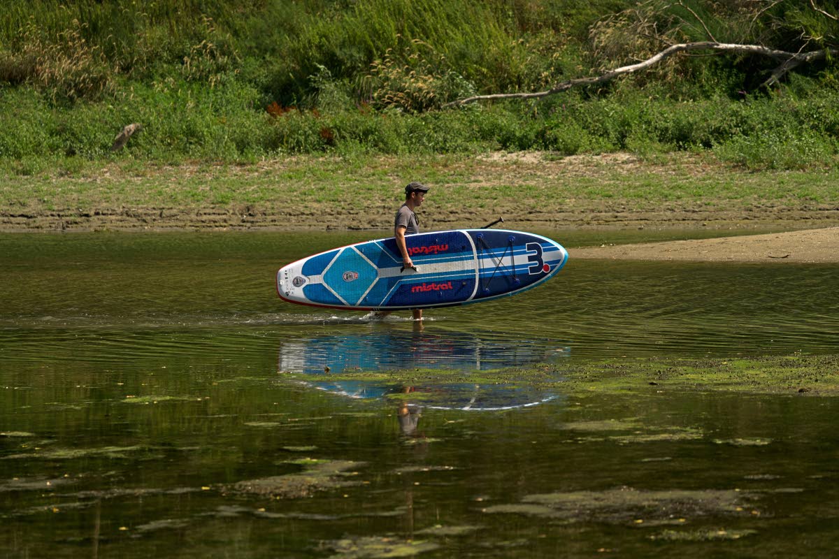 A man takes in his boat on sandbanks exposed by record-low water levels in the Danube River after drought and extreme heat.