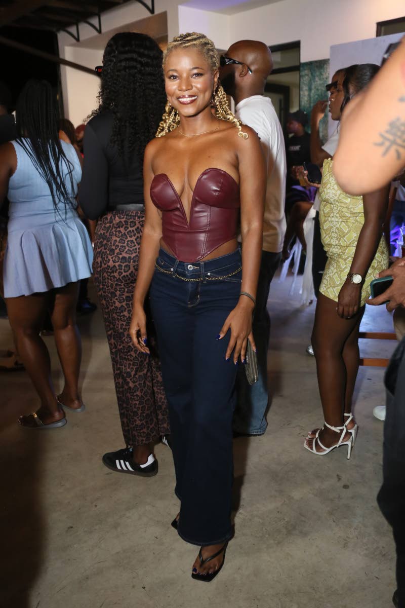 Aviation professional Shadeen Reid pairs a plunging bustier top with dark-blue denim jeans.