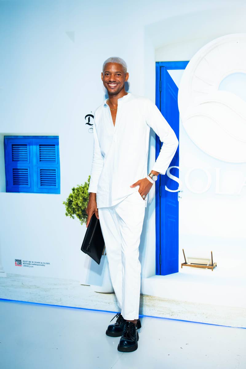 Fashion designer Lucien Harrison looks crisp in white, pairing his outfit with chunky black shoes and a matching bag.
