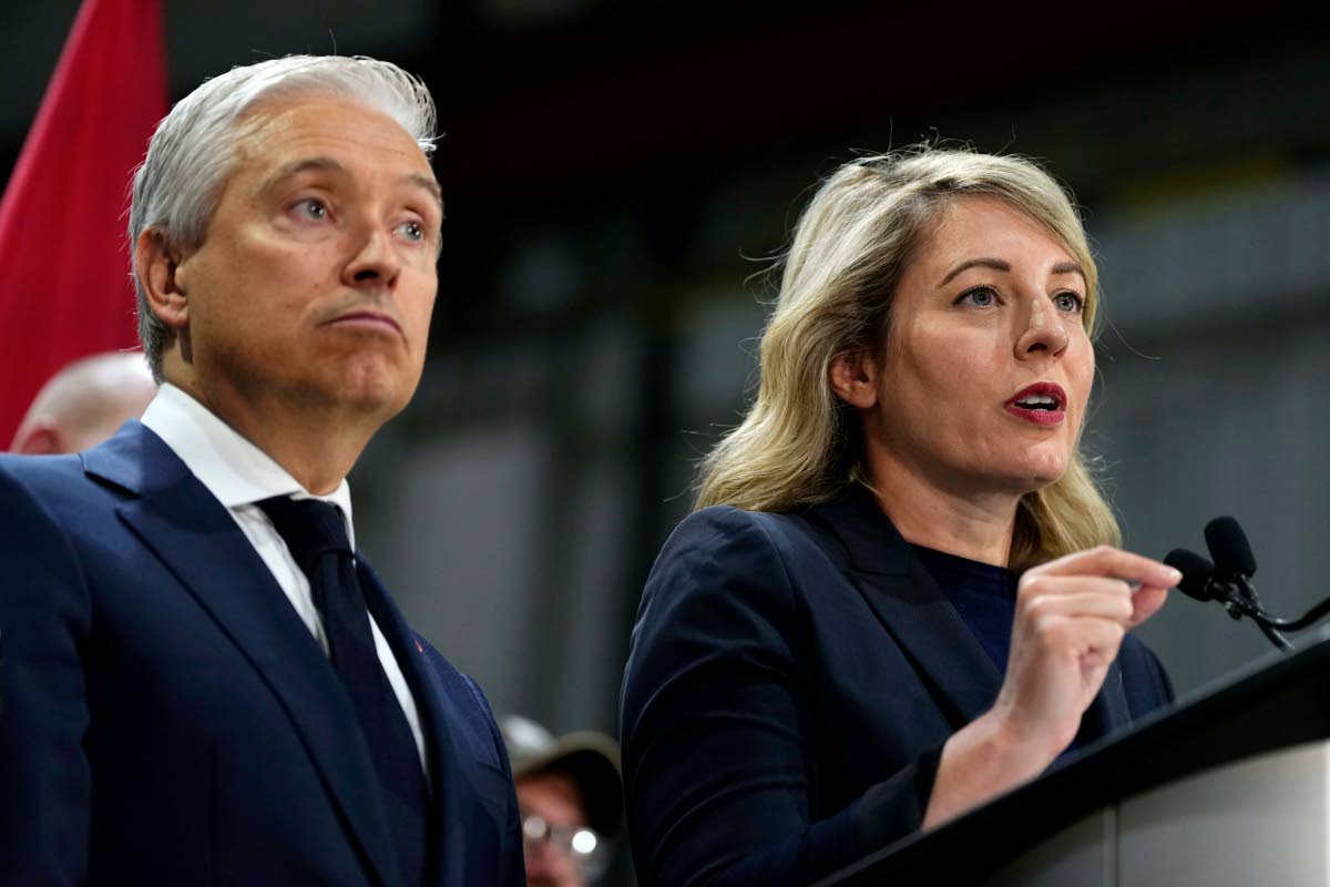 Canada Minister of Industry Melanie Joly speaks as Minister of Finance and National Revenue Francois-Philippe Champagne looks on at a news conference on Canada’s response to U.S. tariffs, at a roofing company in Ottawa, on Tuesday, Aug. 25, 2026. (Justin