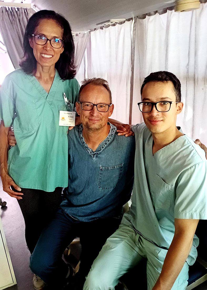 A family of dentists, Dr Adam Szymczak (centre), his wife Joanne, and their son Justin, pose inside Great Shape!’s mobile clinic.