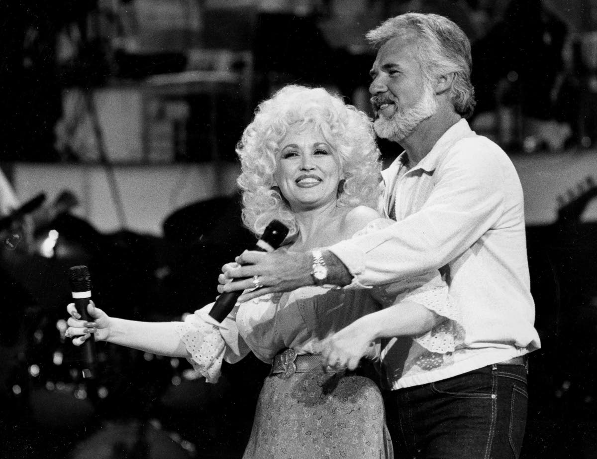 Dolly Parton (left) and Kenny Rogers rehearse a song for their appearance on the TV show ‘Live... And in Person’ in Los Angeles on September 27, 1983. 