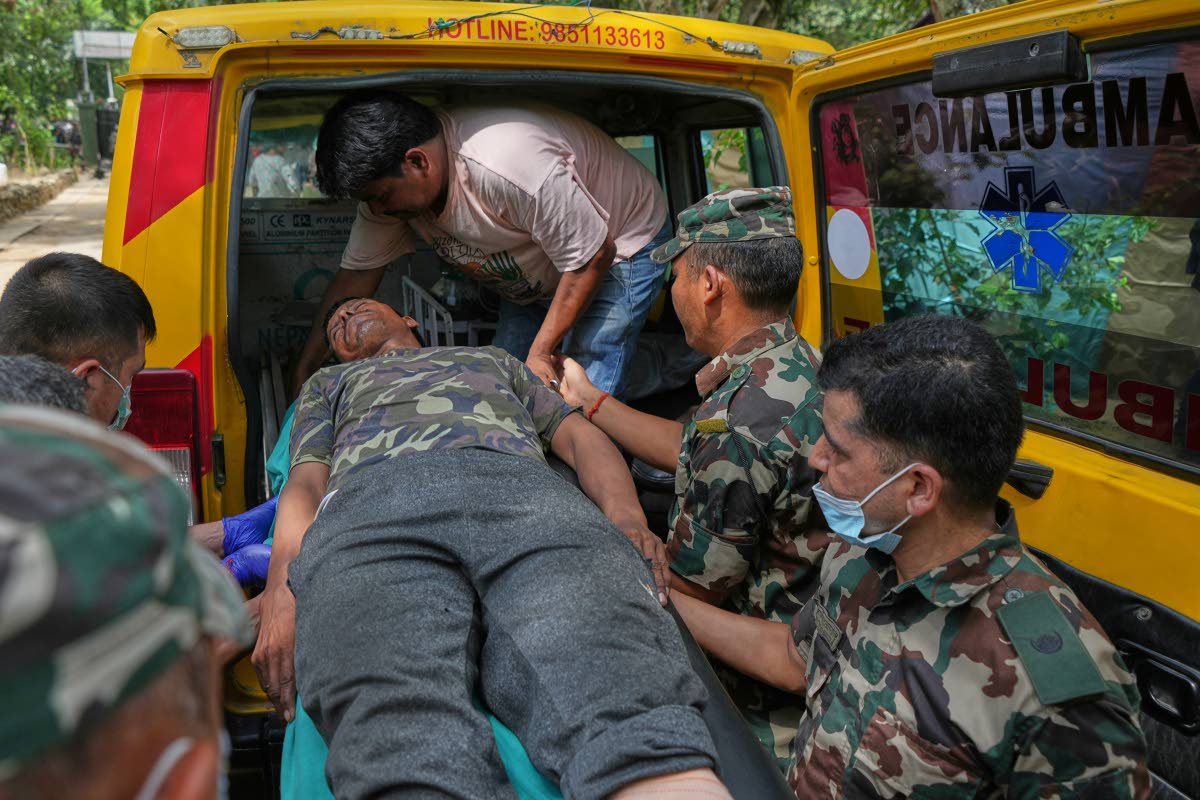 An injured rescued person from flash flooding is taken to a hospital in Nepal’s Nuwakot district on Friday.
